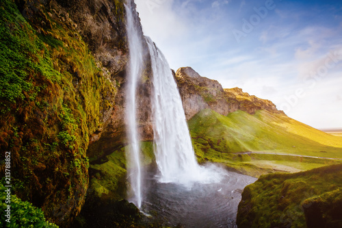 Perfect view of famous powerful Seljalandfoss waterfall in sunlight.