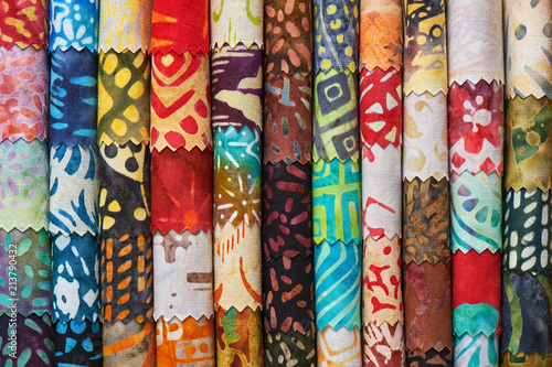 Stack of colorful quilting batik fabrics as a vibrant background image