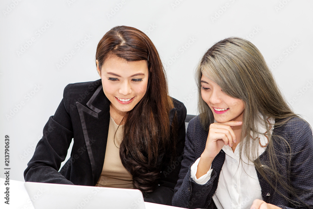 Portrait of two businesswoman using laptop in office. asian people. Portrait of two businesswoman using laptop in office. asian people.