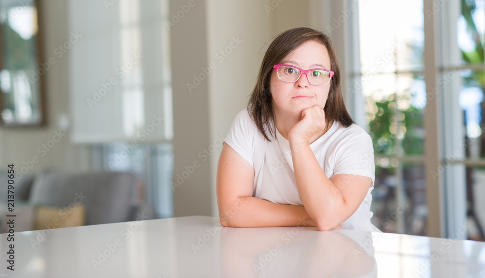 Down syndrome woman at home serious face thinking about question, very confused idea