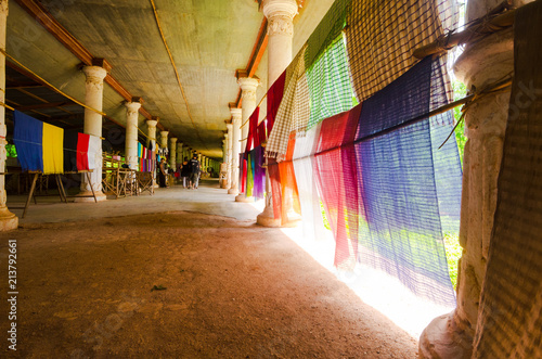 Hanging Longji clothes fly in the wind in a covered gallery on the shores of Inle Lake, Myanmar. photo