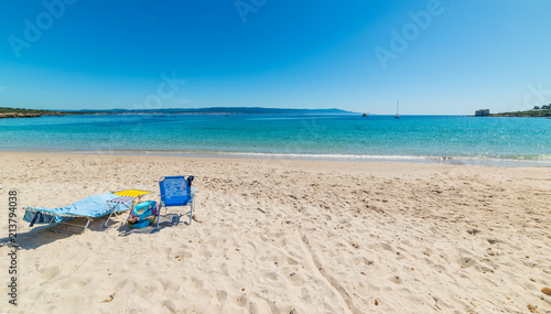 Beach chairs on the sand in Lazzaretto beach in Alghero
