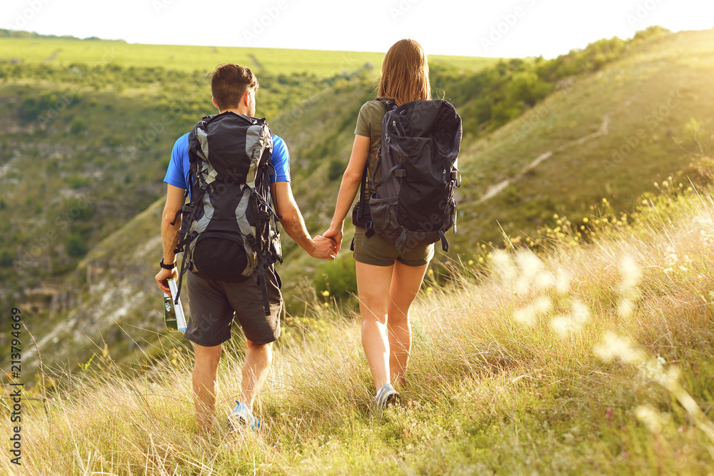 Happy couple of tourists with backpacks on nature. Back view. Happy couple of tourists with backpacks on nature. Back view.