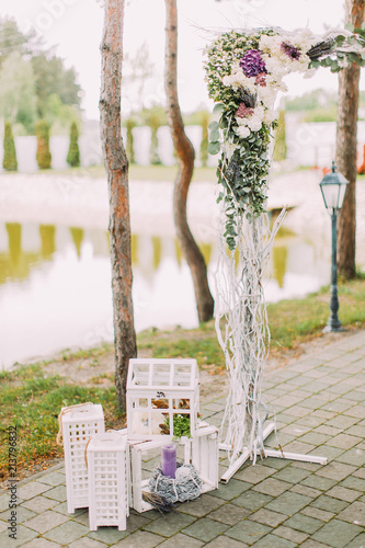 Open air wedding composition. The part of the flower wedding arch and vintage boxes with candles. photo