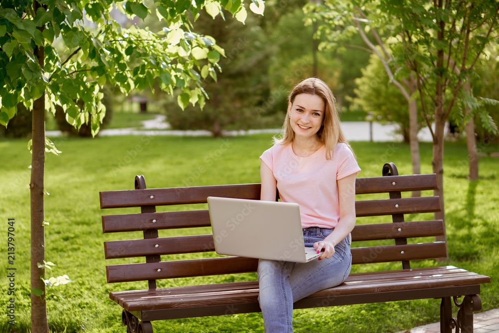 girl with a laptop sitting on a bench girl with a laptop sitting on a bench
