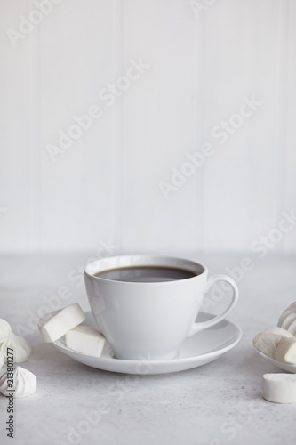 Cup of coffee on white background. Marshmallows, sweets and coffee beans.