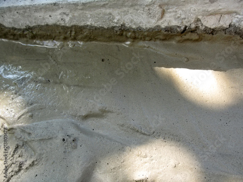 Background of solidifying wet cement on the ground. Pouring concrete floor - gray texture