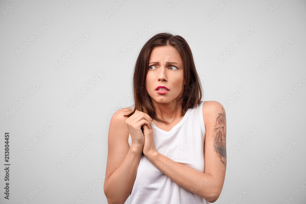 Girl is worrying. Portrait of concerned attractive caucasian female student holding palms on chest and gasping from fear and anxiety, wanting to help in trouble Girl is worrying. Portrait of concerned attractive caucasian female student holding palms on chest and gasping from fear and anxiety, wanting to help in trouble