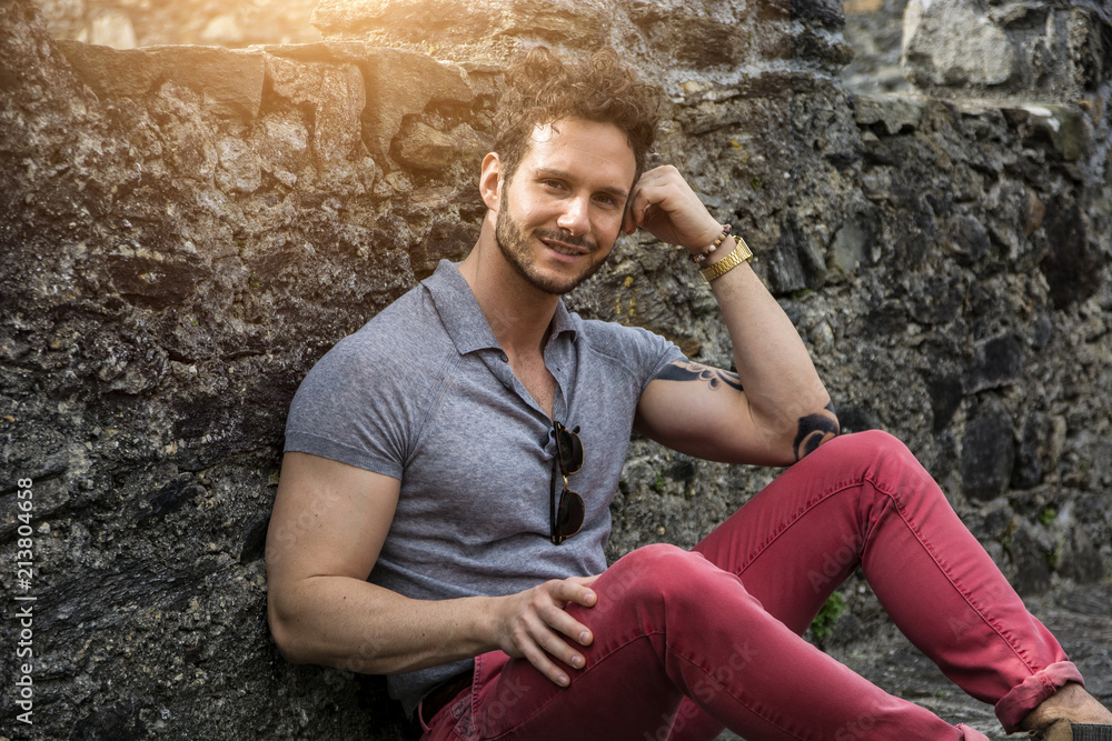 Attractive man outdoor in old European castle, in Switzerland. Athletic build, with tight t-shirt and sunglasses Attractive man outdoor in old European castle, in Switzerland. Athletic build, with tight t-shirt and sunglasses