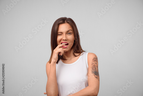 Wallpaper Mural Beautiful female looks at camera having her brunette hair biting her finger, building plans, thinking about something, making decision. Face expression, feelings and attitude Torontodigital.ca