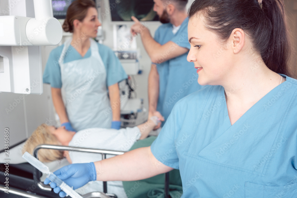 Team of nurses and doctors preparing for endoscopy examination greeting patient Team of nurses and doctors preparing for endoscopy examination greeting patient