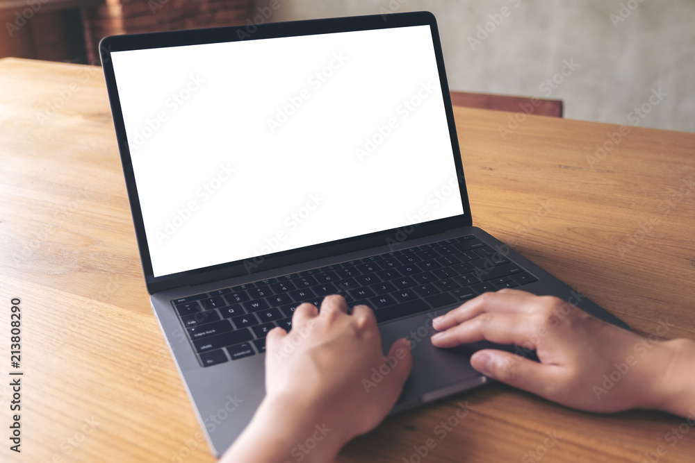Mockup image of a woman using laptop with blank white desktop screen on wooden table Mockup image of a woman using laptop with blank white desktop screen on wooden table
