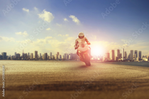 man riding big motorcycle on sharp curve against city building scene photo