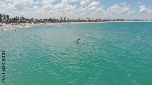 rotating shot of people paddling kayak on the blue sea in Brazil, porto de galinhas