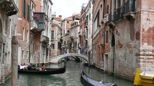 Two gondolas navigating narrow canals in Venice, Italy