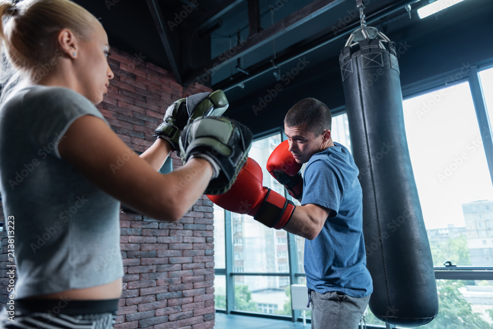 Athletic businessman. Dark-haired handsome athletic businessman spending his weekend in gym with trainer Athletic businessman. Dark-haired handsome athletic businessman spending his weekend in gym with trainer