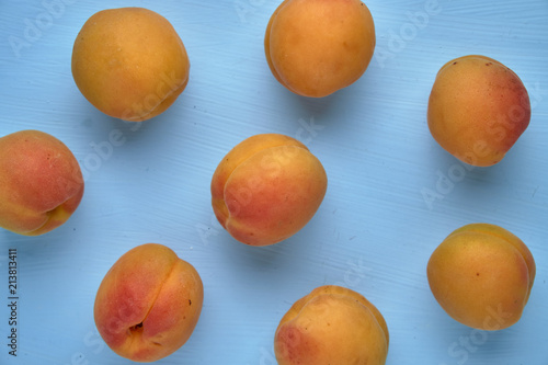 Delicious ripe apricots on a blue background with a top view, organic healthy food.