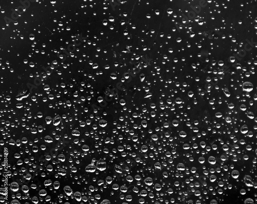 on a black background many drops of rain gradient size from big to small