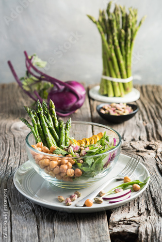 Vegetarian salad, Buddha bowl with asparagus, arugula, zucchini, kohlrabi, pistachio and chickpeas. Selective focus