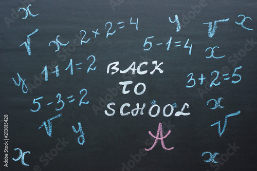 Text Back to school and mathematical examples on black chalkboar