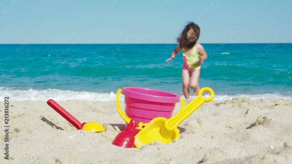Child on the beach playing with sand. Little girl is playing on the beach. Child on the beach playing with sand. Little girl is playing on the beach.