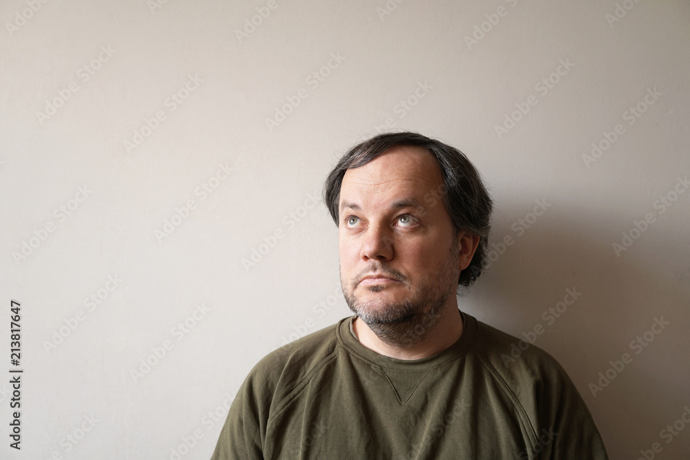 thoughtful middle aged man looking up to copy space