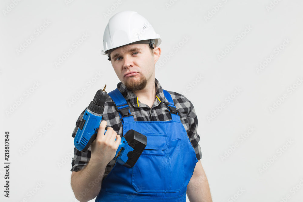Funny builder standing with screwdriver on white background
