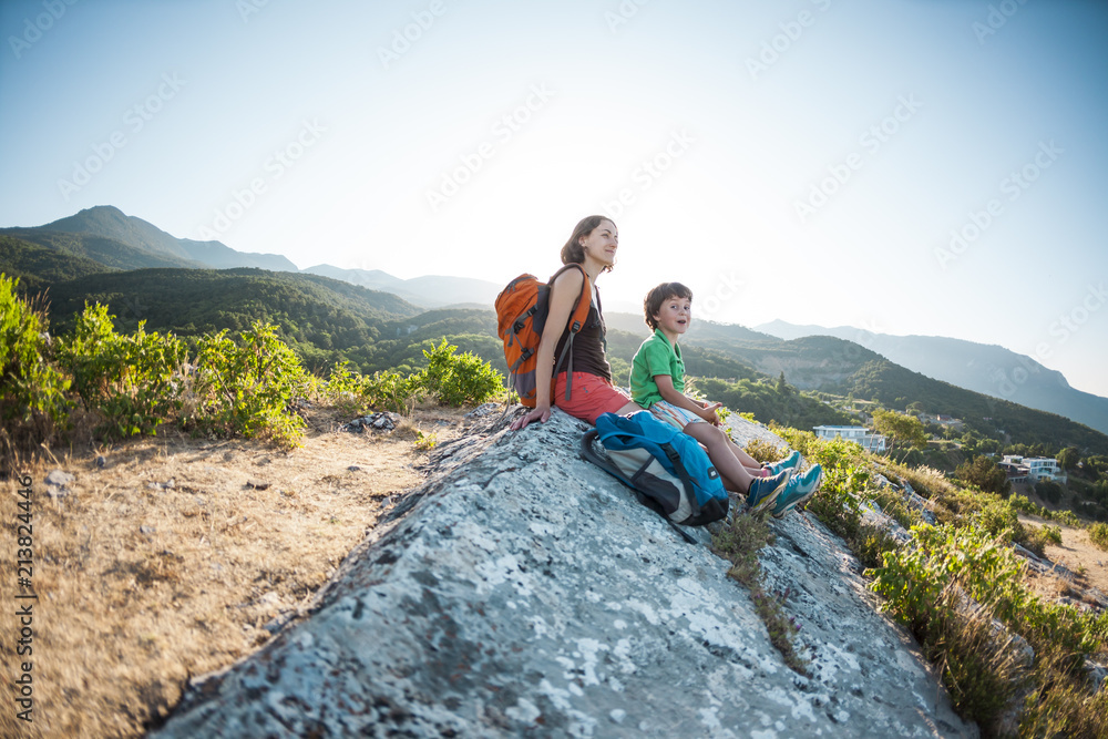 A woman with a child is sitting on top of a mountain.