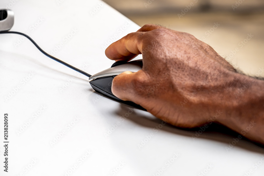 African man using mouse to control the computer African man using mouse to control the computer