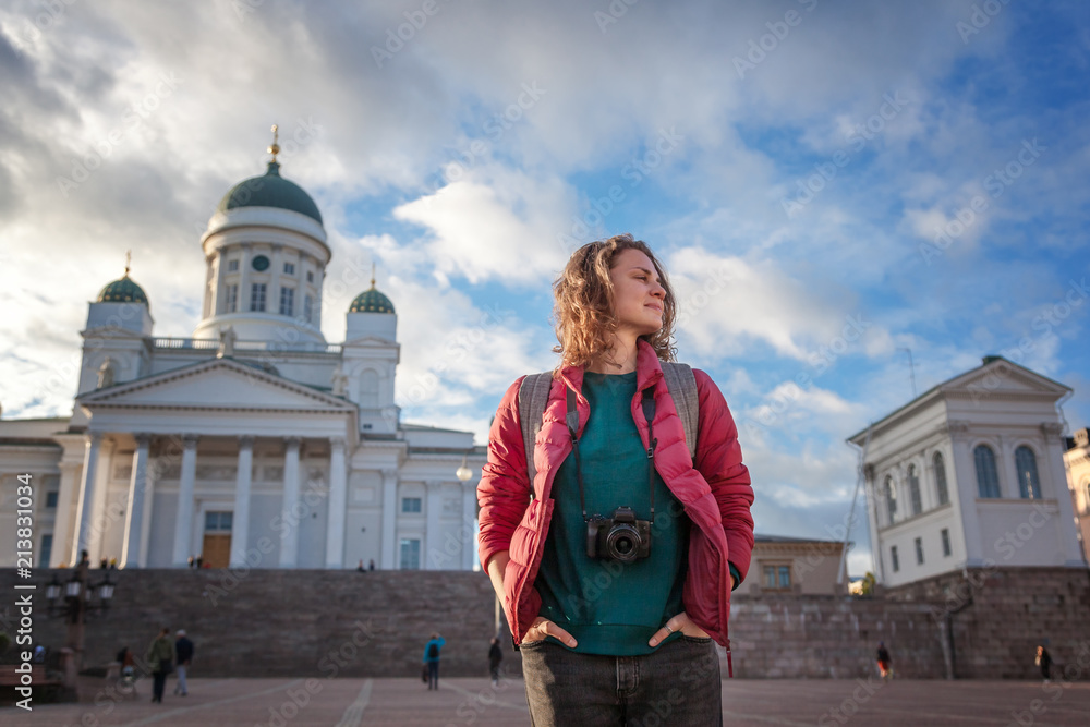 A beautiful young woman traveler with a camera on Senate Square in Helsinki, the capital of Finland, a popular destination for traveling to Northern Europe