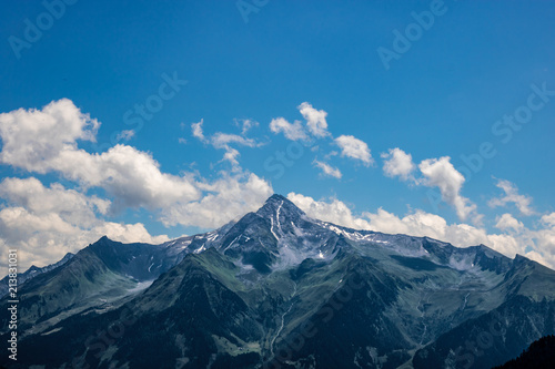 Summit of the mountain "Ahornberg" in zillertal/austria with rocks, green meadow and blue sky