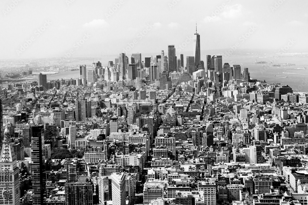 Cityscape skyline of various buildings, skyscrapers and architecture looking down on midtown Manhattan in New York City towards downtowns Financial District in black and white