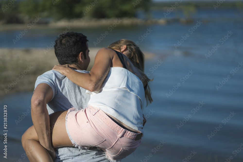 Romantic couple playing outdoors by the lake Romantic couple playing outdoors by the lake