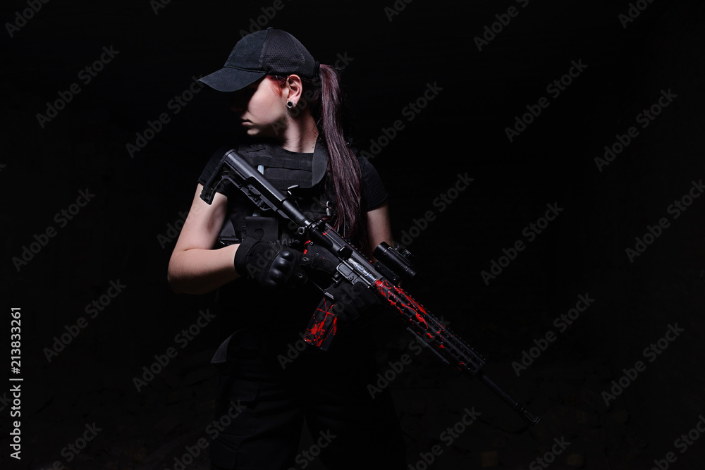 Girl with rifle on dark background