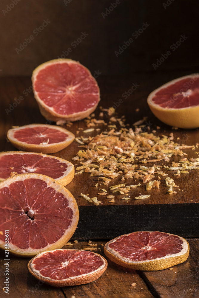 Sliced grapefruit with grated peels in window light Sliced grapefruit with grated peels in window light