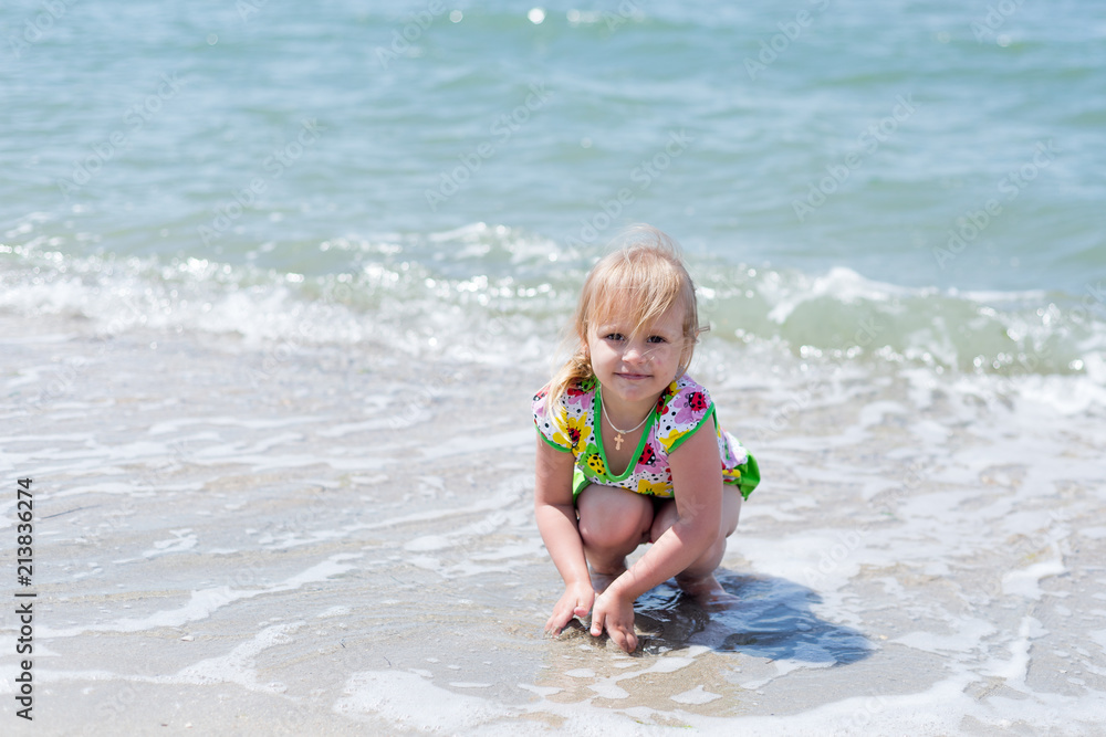 A child, a little girl playing fun on the seashore in the summer. A child, a little girl playing fun on the seashore in the summer.