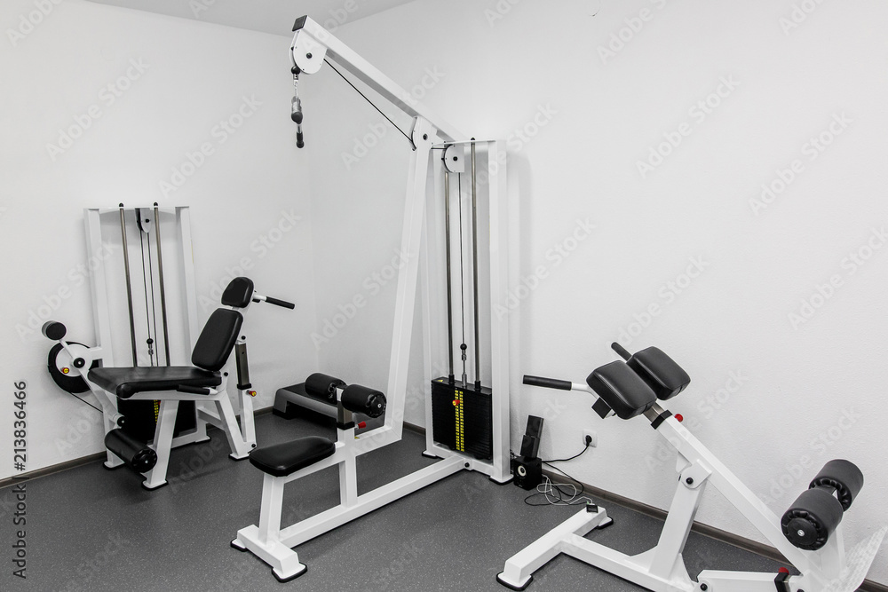 Obraz premium modern gym weight training equipment for exercises and rehab for legs and back. rehabilitation equipment in therapy clinic. fitness wellness concept. space for text
