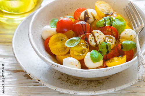 Delicious summer salad of yellow and red cherry tomatoes, mozzarella with Basil, spices and balsamic. Caprese