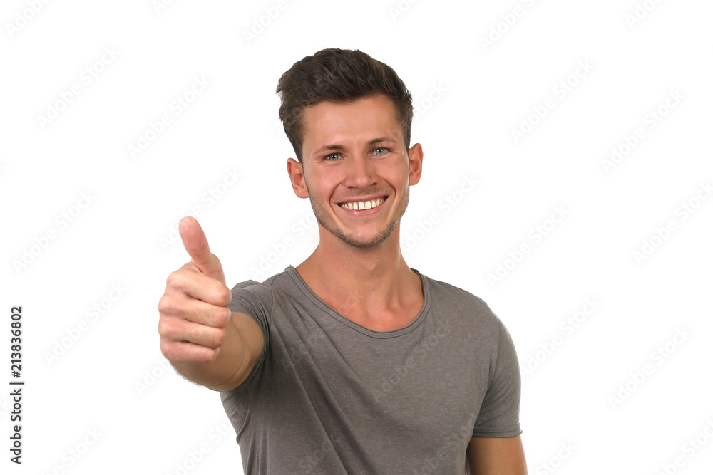 Junger Mann zeigt lachend Daumen hoch Junger Mann zeigt lachend Daumen hoch