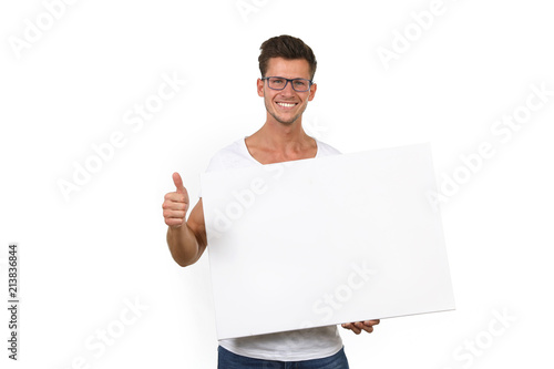 Junger Mann mit Brille hält eine leere Leinwand  vro sich und zeigt lachend Daumen hoch photo