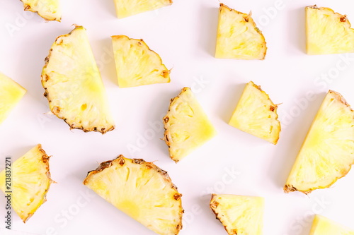 Pattern made of sliced pineapples. Slices of pineapple on a light pastel pink background. Summer concept. Flat lay, top view, copy space 