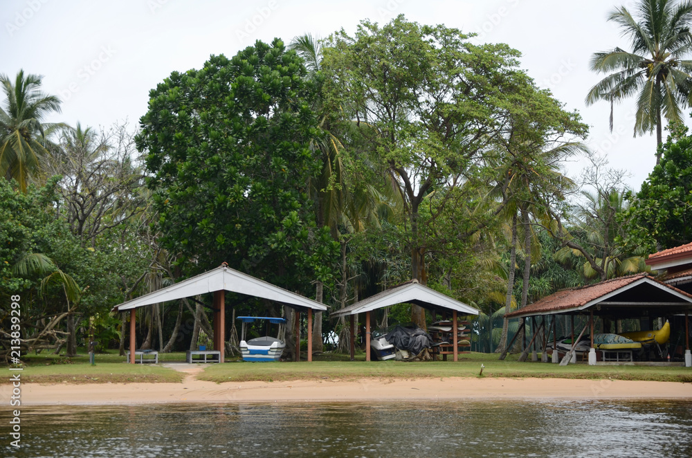 Obraz premium Bentota, Sri Lanka - May 04, 2018: Hangar with boats, scooters, surfboards. Coast of the Bentota Ganga