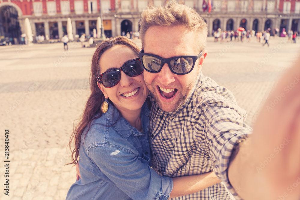 happy couple taking selfie on smart phone in Madrid Spain