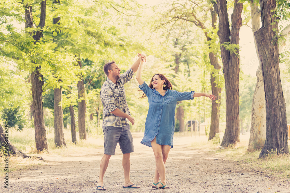 young pretty couple dancing in a green park young pretty couple dancing in a green park