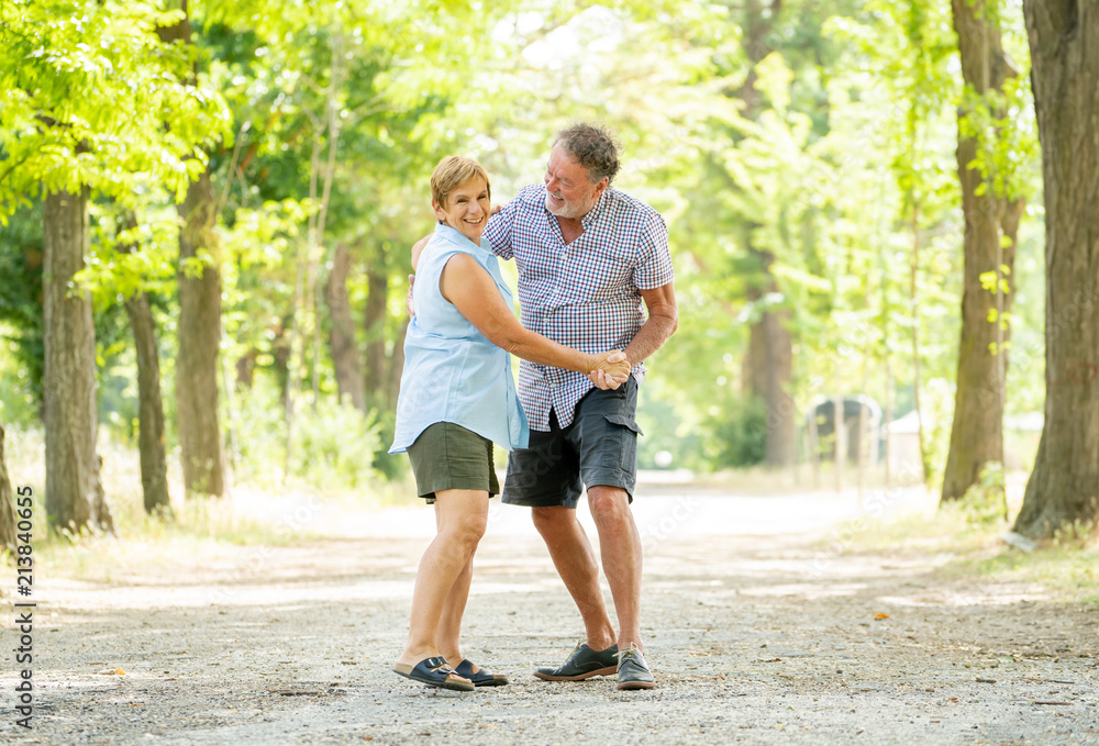 Portrait of a beautiful happy senior couple in love dancing in the park