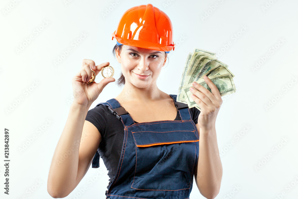 Young woman in helmet with banknotes and bitcoin on white background. Young woman in helmet with banknotes and bitcoin on white background.