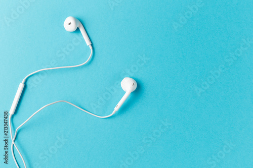 Flat lay concept: headphones on pastel backgrounds. white headphones on a blue background, top view, copyspace. Trendy colorful photo. Minimal style with colorful paper backdrop. photo