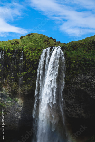 A waterfall in Iceland during a clear blue sky