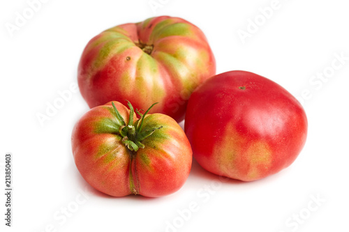 Imperfect heirloom organic tomatoes isolated on white background