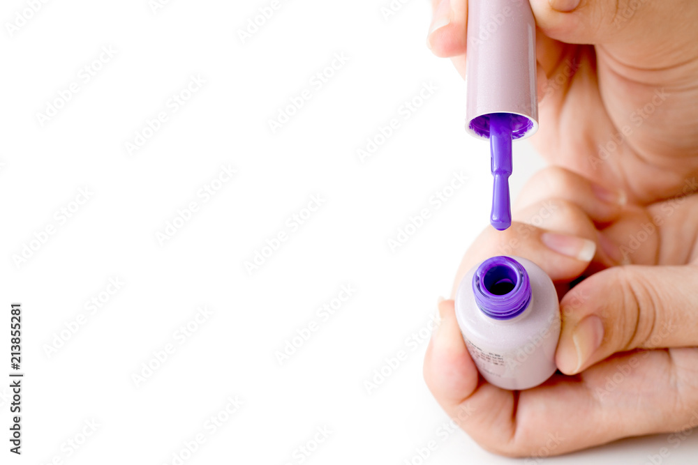 Beauty, fashion and Nail art concept. Manicure in nails spa salon -woman hands close-up with bottle and brush of purple gel nail polish. isolated on white background. copy space Beauty, fashion and Nail art concept. Manicure in nails spa salon -woman hands close-up with bottle and brush of purple gel nail polish. isolated on white background. copy space
